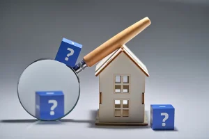 Toy house, magnifying glass, and blocks with question marks on them