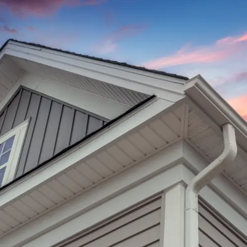 Corner of roof with gutters and white drip edge at sunset